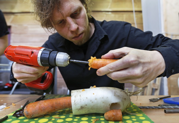 Austrian musician Matthias Meinharter, who is a member of the Vegetable Orchestra, uses a hand drill to make a musical instrument from a carrot during the preparations for a concert in Haguenau, eastern France